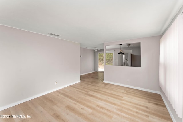 empty room with light hardwood / wood-style flooring and ceiling fan