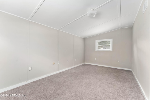 carpeted spare room with lofted ceiling