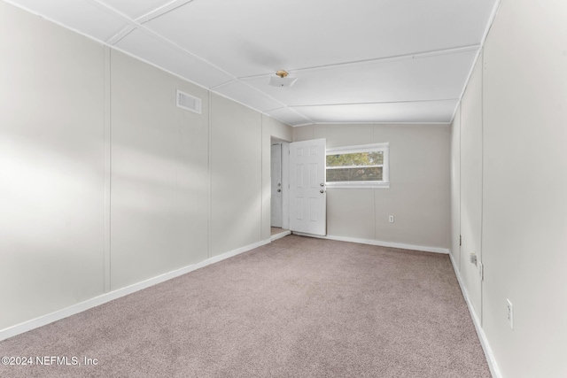 carpeted empty room with lofted ceiling