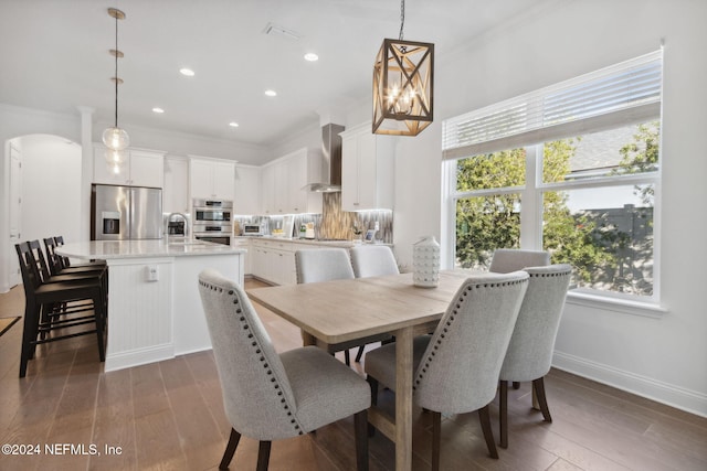 dining room with a wealth of natural light, crown molding, and dark wood-type flooring