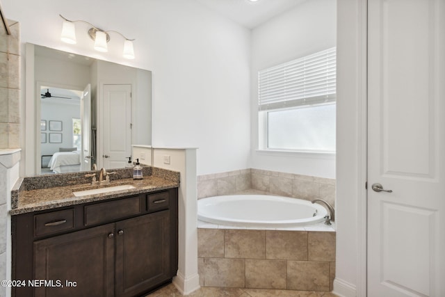 bathroom featuring vanity, ceiling fan, tile patterned flooring, and a relaxing tiled tub