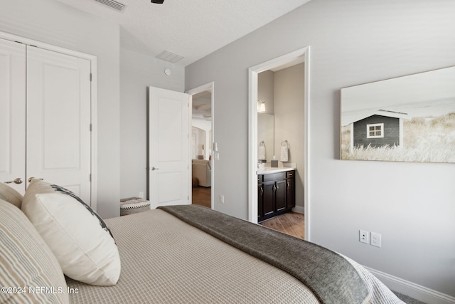 bedroom featuring connected bathroom, a closet, and wood-type flooring