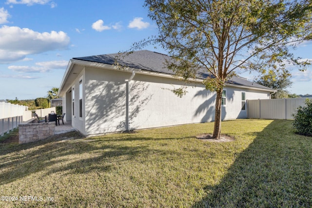 back of house featuring a lawn and a patio