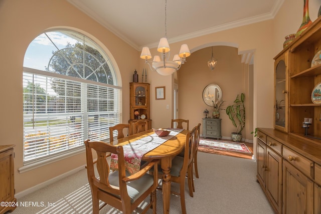 dining area with a notable chandelier, light colored carpet, ornamental molding, and a wealth of natural light