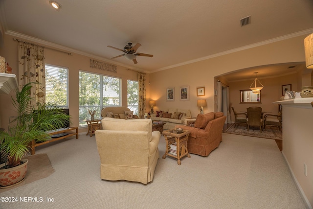 carpeted living room featuring ceiling fan and crown molding