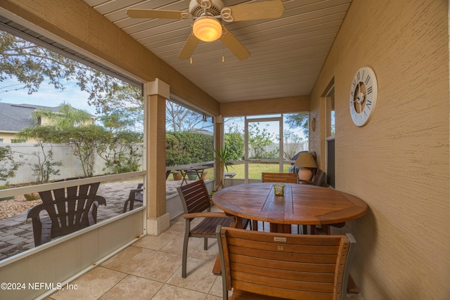 sunroom with ceiling fan and wooden ceiling