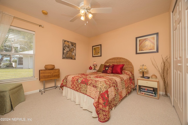 bedroom with ceiling fan, carpet floors, a textured ceiling, and a closet