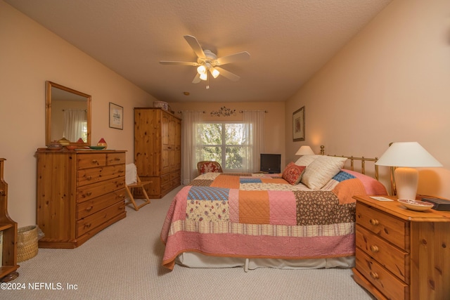 carpeted bedroom featuring a textured ceiling and ceiling fan