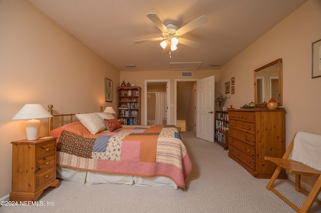 bedroom with ceiling fan, a textured ceiling, and light carpet