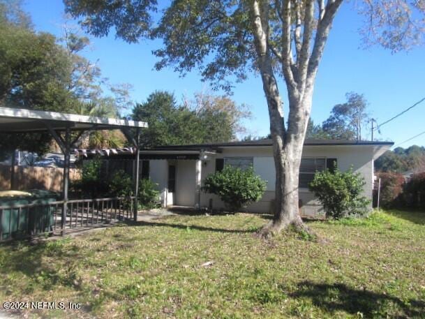 rear view of property featuring a lawn