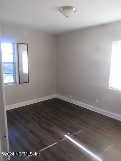 empty room with dark hardwood / wood-style floors