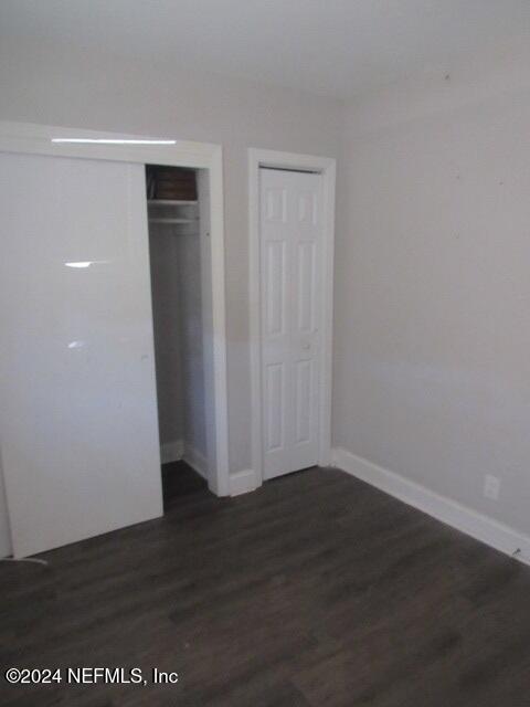 unfurnished bedroom featuring dark wood-type flooring