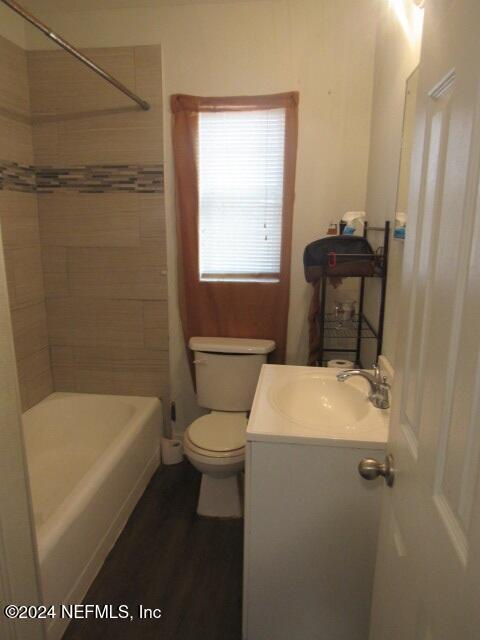 full bathroom with vanity, tiled shower / bath combo, and toilet