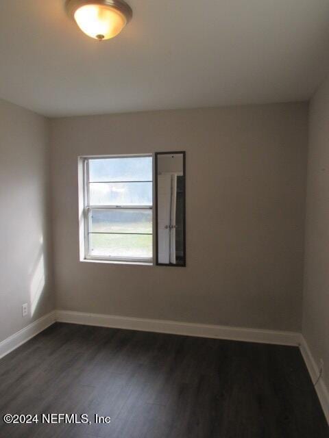 empty room with dark hardwood / wood-style flooring