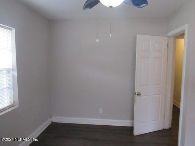 spare room with ceiling fan and dark wood-type flooring