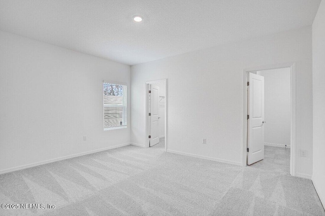 carpeted empty room featuring a textured ceiling