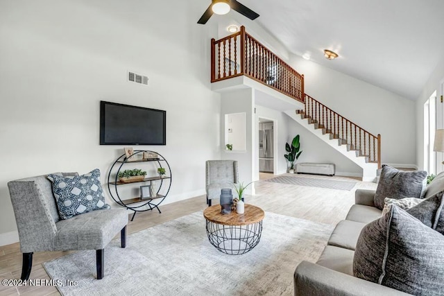 living room featuring ceiling fan, light hardwood / wood-style floors, and high vaulted ceiling