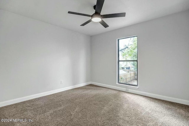 carpeted spare room featuring ceiling fan