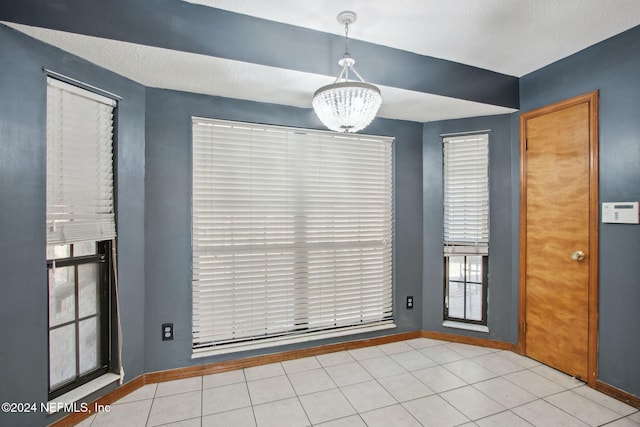 unfurnished dining area featuring light tile patterned floors and an inviting chandelier