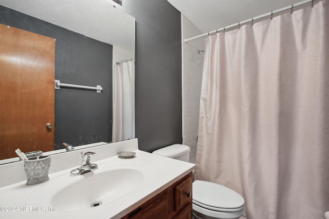 bathroom with vanity, toilet, and a textured ceiling