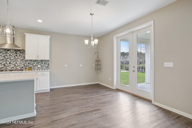 kitchen featuring gas cooktop, backsplash, white cabinetry, and pendant lighting