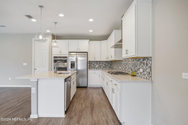 kitchen featuring pendant lighting, white cabinets, stainless steel appliances, sink, and a center island with sink