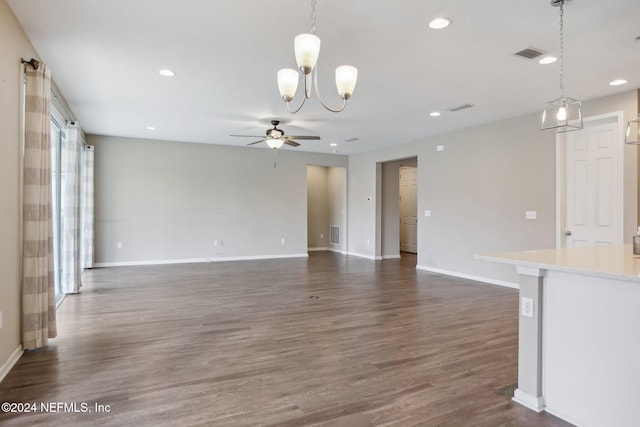 unfurnished living room with ceiling fan with notable chandelier and dark hardwood / wood-style flooring