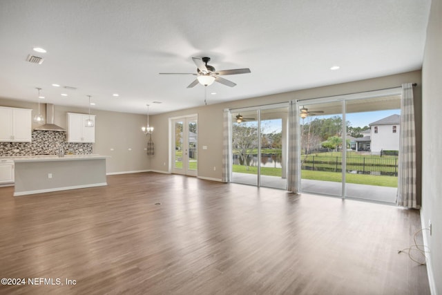 unfurnished living room with ceiling fan and dark hardwood / wood-style flooring