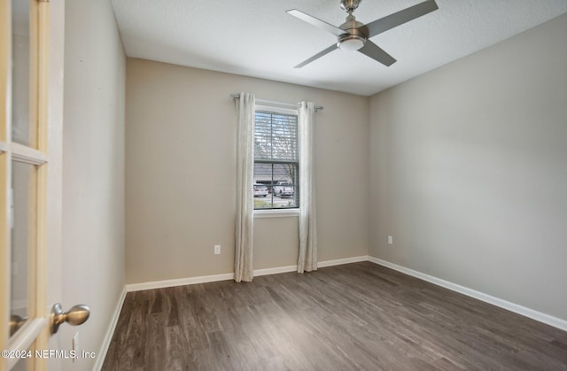 unfurnished room featuring ceiling fan, dark wood-type flooring, and a textured ceiling