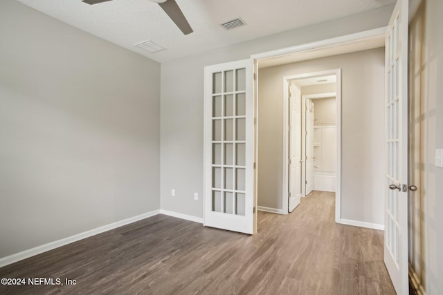 empty room with ceiling fan, french doors, and dark hardwood / wood-style floors