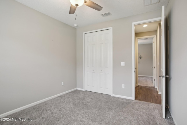 unfurnished bedroom with ceiling fan, a closet, and carpet flooring