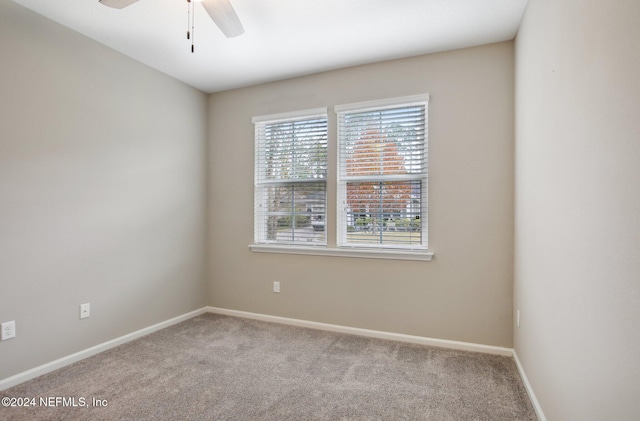 spare room with light colored carpet and ceiling fan