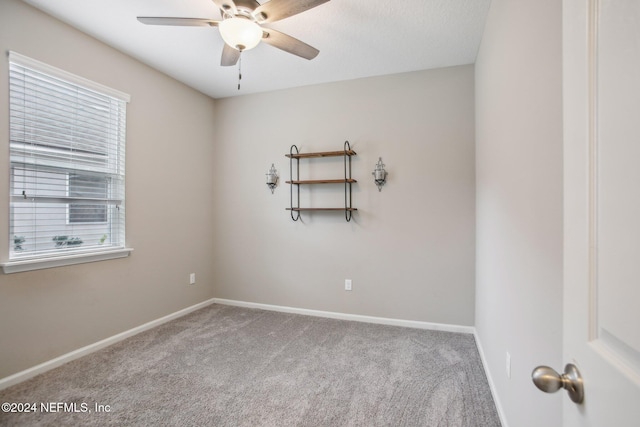 unfurnished room featuring ceiling fan, light colored carpet, and plenty of natural light