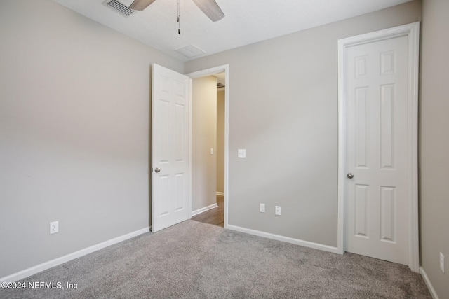 unfurnished bedroom with ceiling fan and carpet