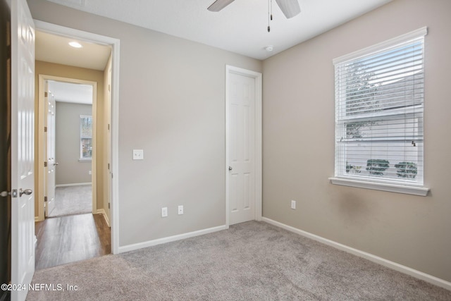 unfurnished bedroom featuring light colored carpet and ceiling fan