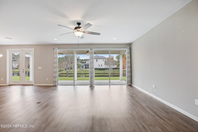 spare room featuring ceiling fan, hardwood / wood-style floors, and a wealth of natural light