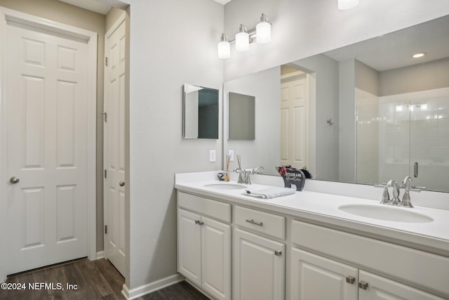 bathroom with wood-type flooring, an enclosed shower, and vanity