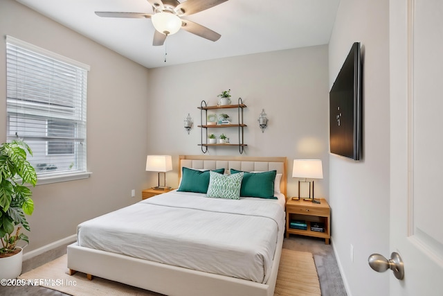 bedroom featuring ceiling fan, multiple windows, and light hardwood / wood-style flooring