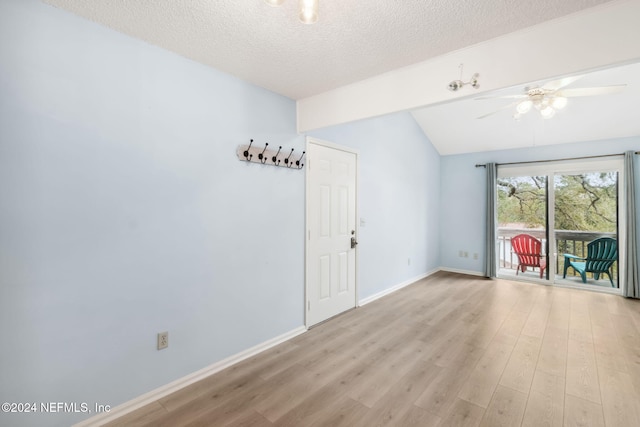 spare room featuring ceiling fan, vaulted ceiling, a textured ceiling, and light hardwood / wood-style flooring