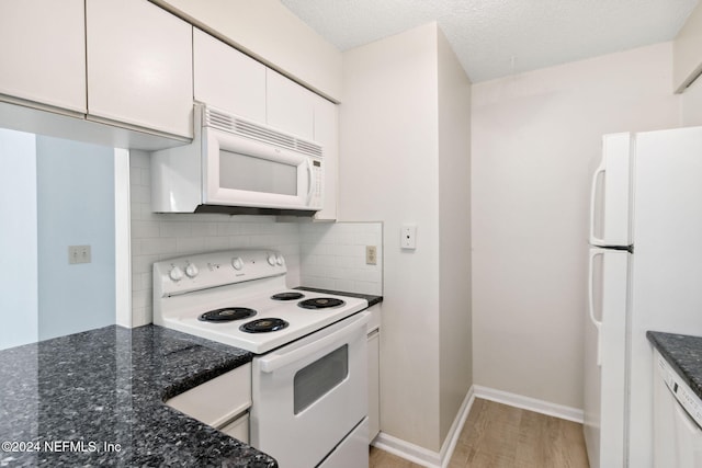 kitchen featuring white appliances, dark stone counters, white cabinets, tasteful backsplash, and light hardwood / wood-style floors