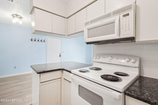 kitchen with white cabinets, white appliances, and tasteful backsplash