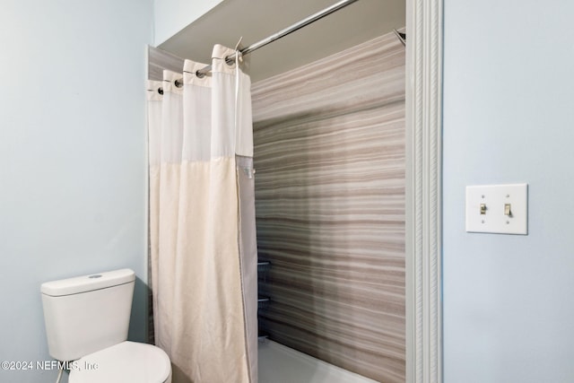 bathroom with a shower with curtain and toilet