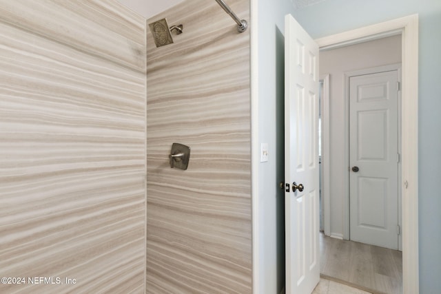 bathroom with hardwood / wood-style flooring and walk in shower