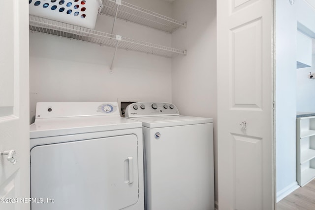 washroom featuring washing machine and dryer and light hardwood / wood-style floors