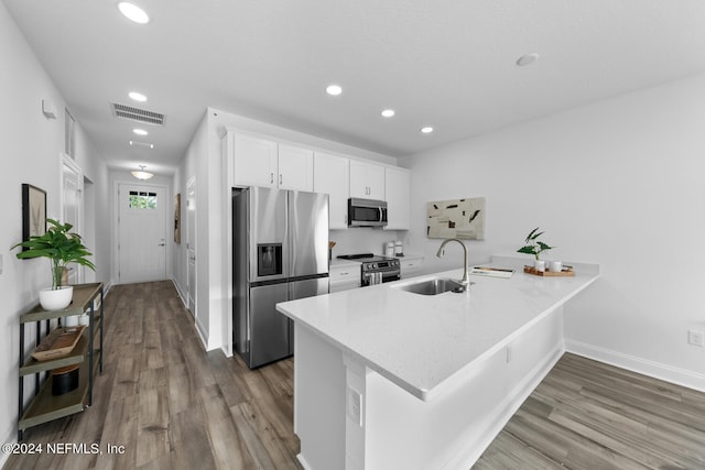 kitchen with white cabinets, sink, kitchen peninsula, and stainless steel appliances