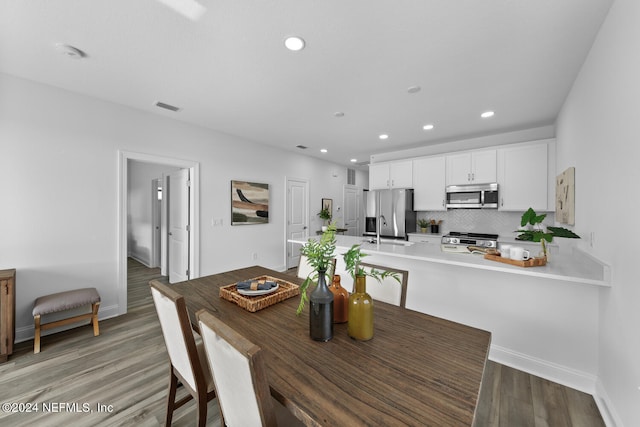 dining space with sink and hardwood / wood-style flooring