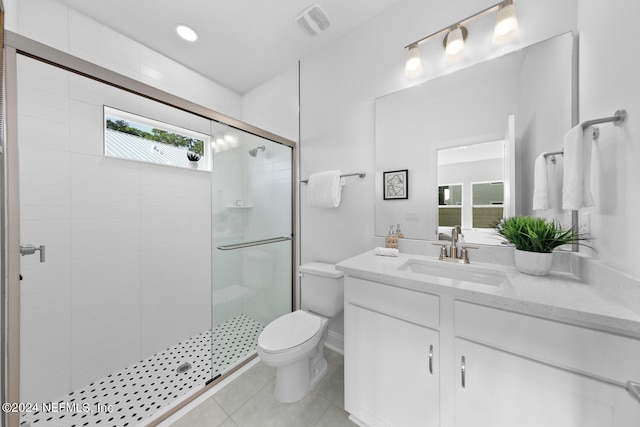 bathroom with an enclosed shower, vanity, toilet, and tile patterned flooring