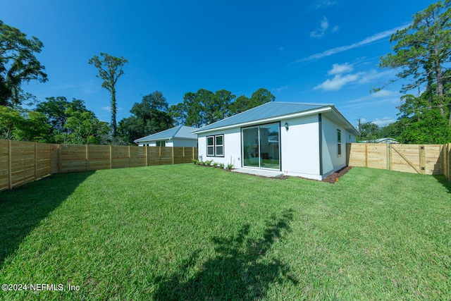 back of property featuring a lawn