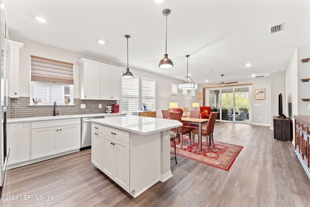 kitchen featuring white cabinetry, dishwasher, a center island, sink, and light hardwood / wood-style floors