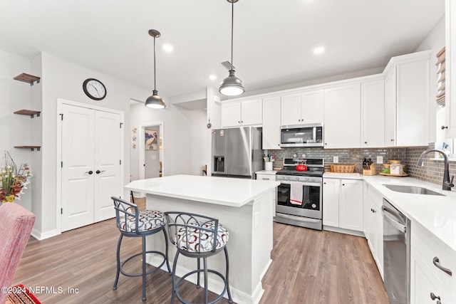 kitchen featuring a center island, sink, white cabinetry, and stainless steel appliances